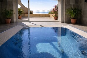 A swimming pool with a clear view of the sea, surrounded by potted plants and a concrete deck. - Elegant Tuscany Holiday Home for 4 (Volterra (PI))