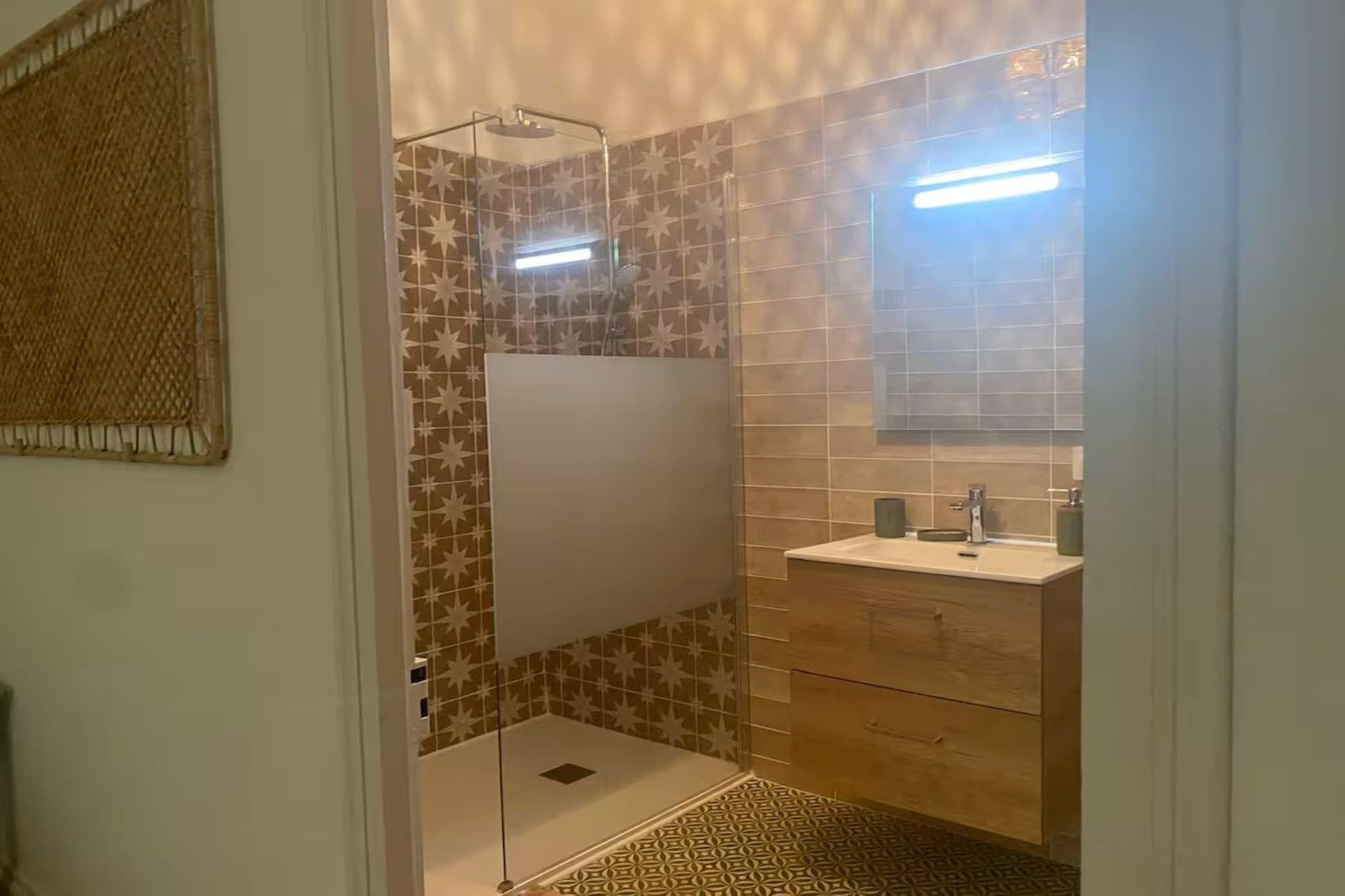 A bathroom with a shower, a sink, and a mirror.