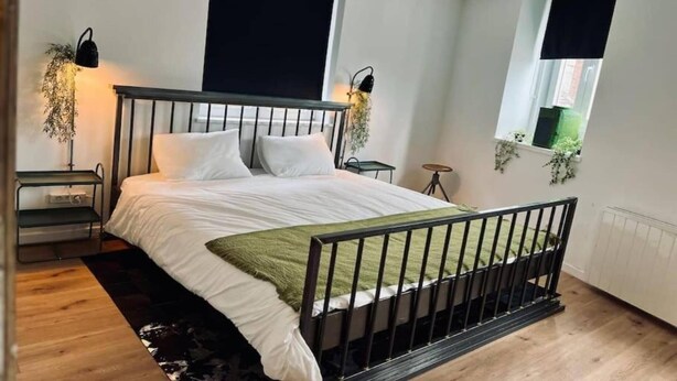 A bedroom with a bed, bedside tables, a window, and a radiator. - Chic vintage apartment in Spa (Spa)