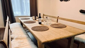 A dining table with placemats, wine bottle, glasses, and a candle. - Chic vintage apartment in Spa (Spa)