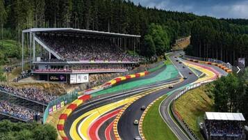 A race track with multiple lanes, grandstands, and a large audience.