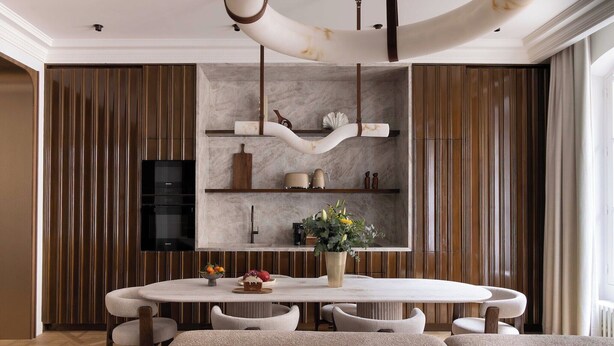 A modern dining area with a marble island, wooden paneling, and a hanging light fixture. - Luxury A/C Apt - 10P/4BDR - Arc de Triomphe (Paris)