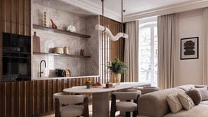 A modern living room with a dining area, wooden paneling, a marble backsplash, and a large window with curtains. - Luxury A/C Apt - 10P/4BDR - Arc de Triomphe (Paris)