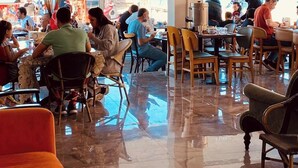 Een restaurant met een betegelde vloer en verschillende tafels en stoelen.