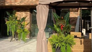 A modern building with a brick facade, large windows, and outdoor seating area with plants and a covered patio. - All Seasons Palanga (Palanga)