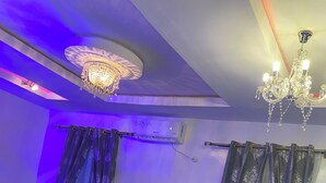 A modern living room with a dark blue sofa, a small side table, and a chandelier. - Make Yourself at Home with Luxury Living and Unmatched Comfort (Osogbo)