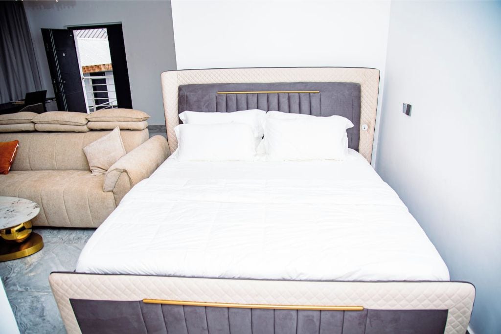 A hotel room with a bed, a sofa, and a small round table.
