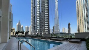 A rooftop pool with a view of high-rise buildings. - Oshima Act Two Downtown 1BR Burj Khalifa (Dubai)