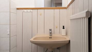 Eenvoudig appartement | Badkamer | Een douche, gratis toiletartikelen, een haardroger, handdoeken