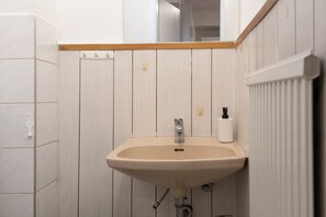 Eenvoudig appartement | Badkamer | Een douche, gratis toiletartikelen, een haardroger, handdoeken