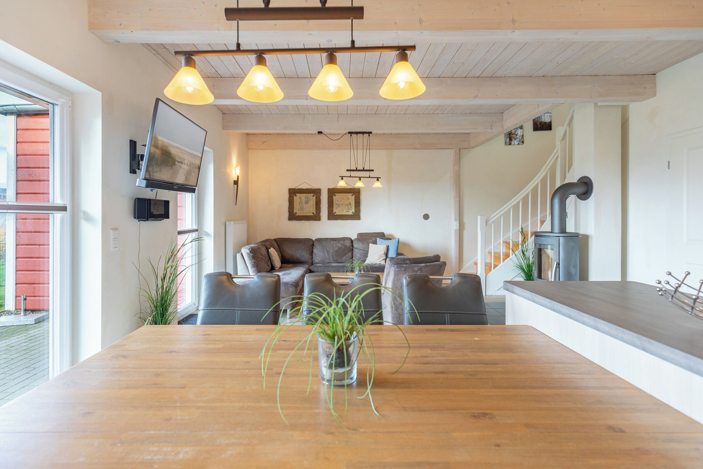 Ein modernes Wohnzimmer mit einem Holzesstisch, einer Sofagarnitur und einem Kamin.