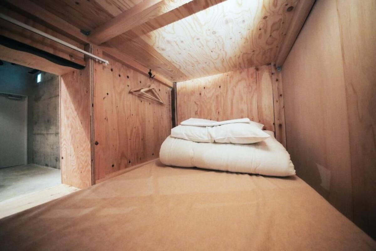 Une petite pièce en bois, avec un lit et un plafond en bois.