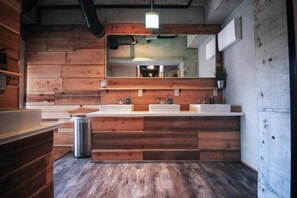 Un baño moderno con paneles de madera, un espejo grande y un tocador.