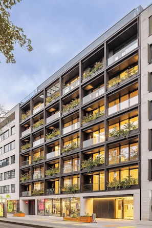 A multi-story building with balconies, each adorned with plants. - Spacious modern apartment-feels like home - short or long, park view - center! (Linz)