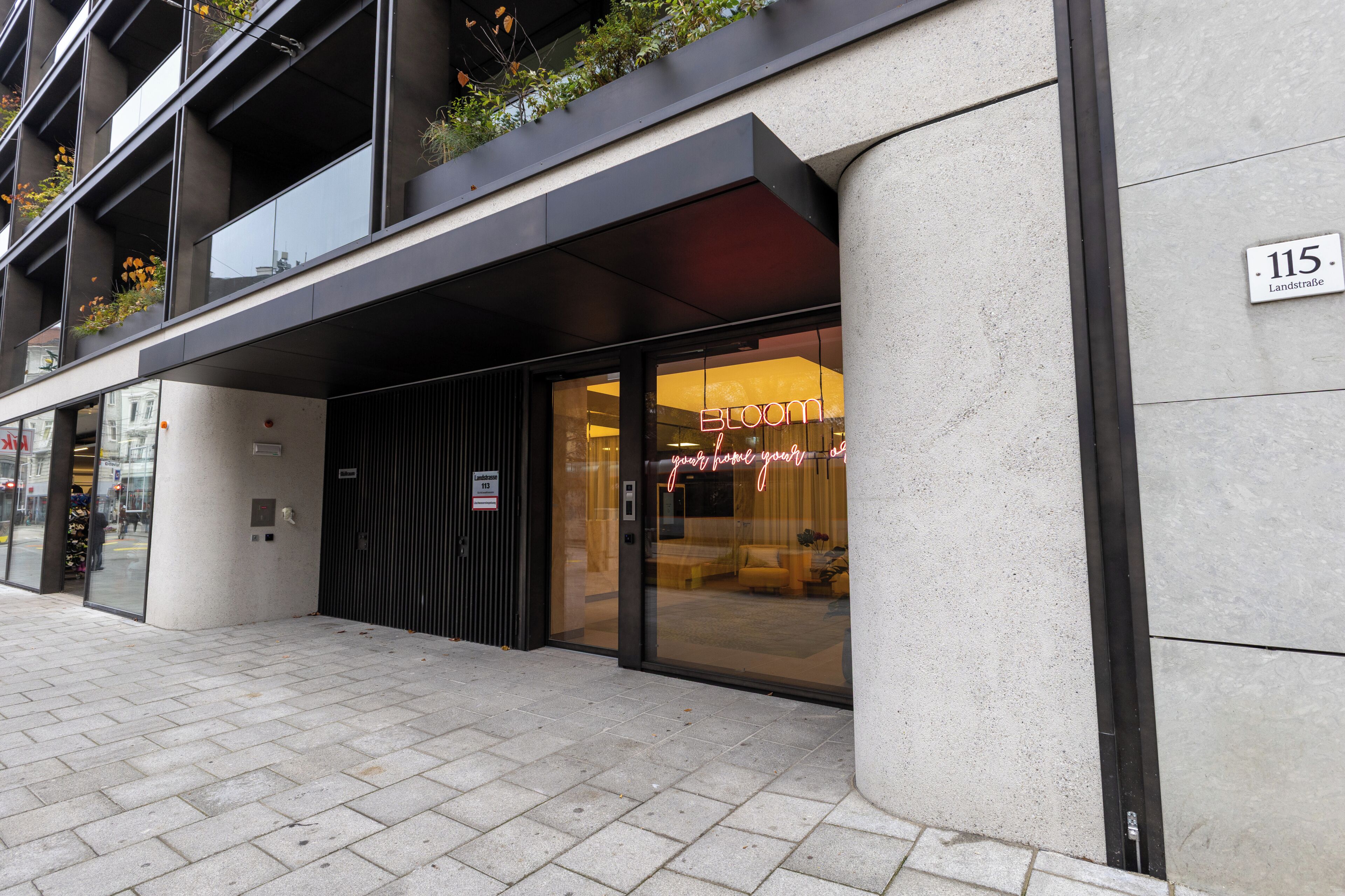 Un bâtiment moderne avec une façade vitrée et une enseigne lumineuse au néon.