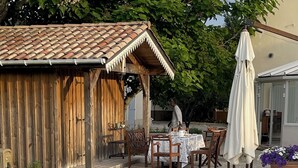 A poolside area with a wooden pergola, outdoor seating, and a tiled pool. - Old Maison de Maitre with great comfort (Gujan-Mestras)