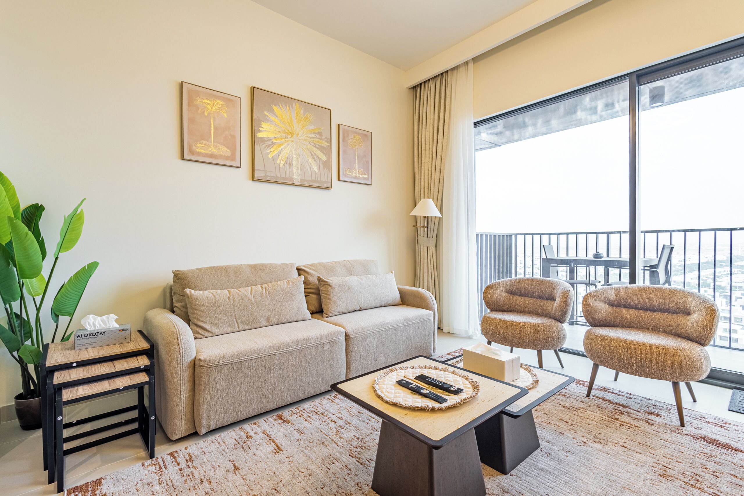 A modern living room with a sofa, armchairs, a coffee table, and artwork on the wall.