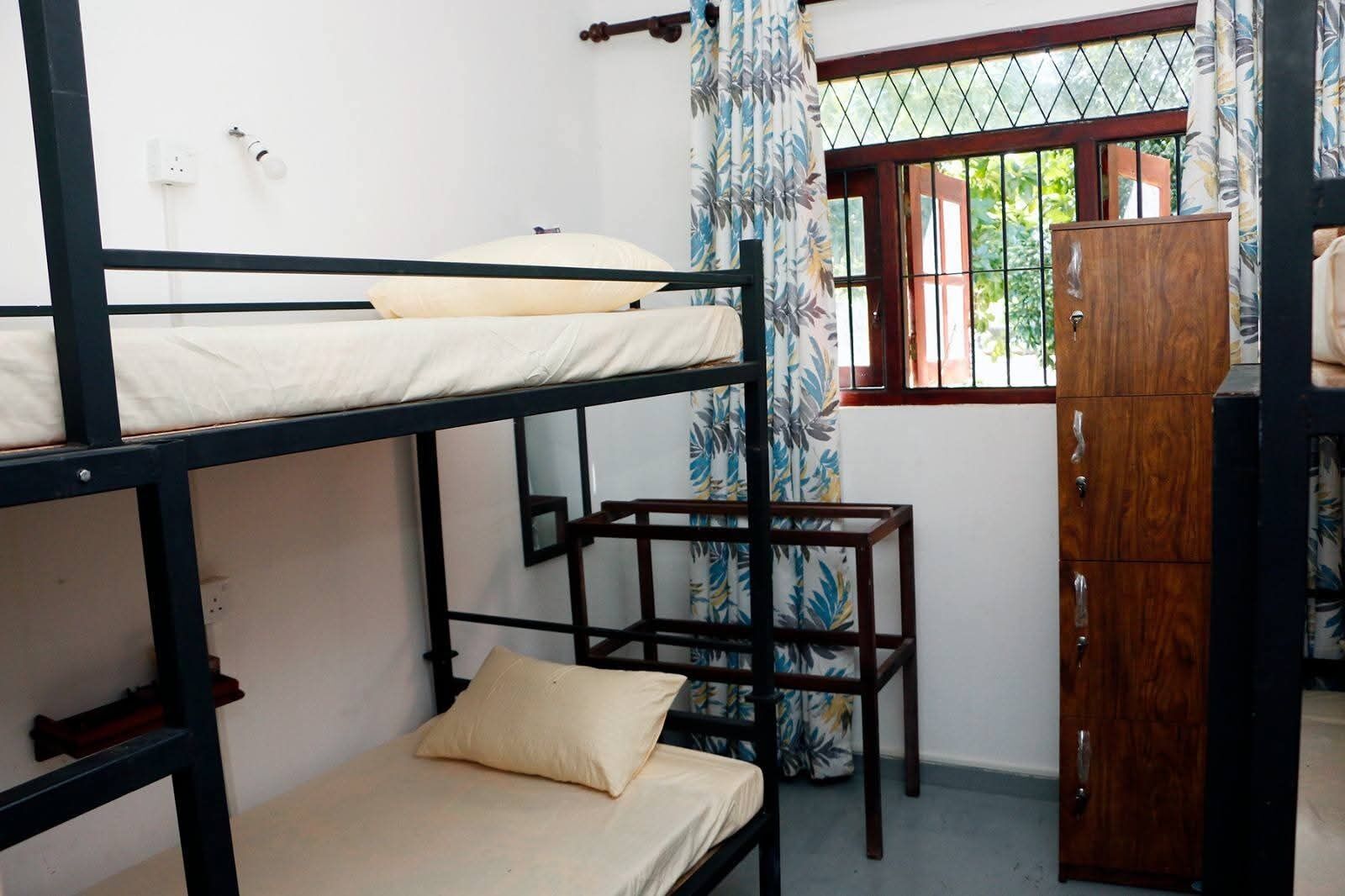 Habitación con literas, un escritorio de madera y un armario.