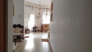 Ein geräumiger Wohnbereich mit einer Couch, einem Tisch und einem Stuhl.