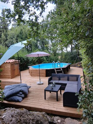 A wooden deck with a pool, outdoor furniture, and a covered area. - House 6/8 persons with swimming pool in a quiet area (La Capelle-et-Masmolène)