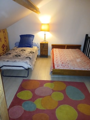 A bedroom with two beds, a nightstand with a lamp, a colorful rug, and a wooden headboard. - House 6/8 persons with swimming pool in a quiet area (La Capelle-et-Masmolène)