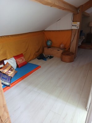 A room with a sloped ceiling, a wooden bench with cushions, a globe, and a small table with a lamp. - House 6/8 persons with swimming pool in a quiet area (La Capelle-et-Masmolène)