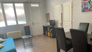 Ein Zimmer mit einem Bett, einem Schreibtisch, einem Stuhl, einem Fernseher und einer Heizung.