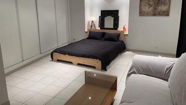 Ein modernes Schlafzimmer mit einem Bett, einem Nachttisch, einem Spiegel und einer Karte an der Wand.