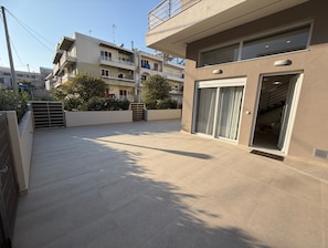 A modern building with a flat roof, large sliding glass doors, and a gated entrance. - Casa Sentido Apartment (Rodos)