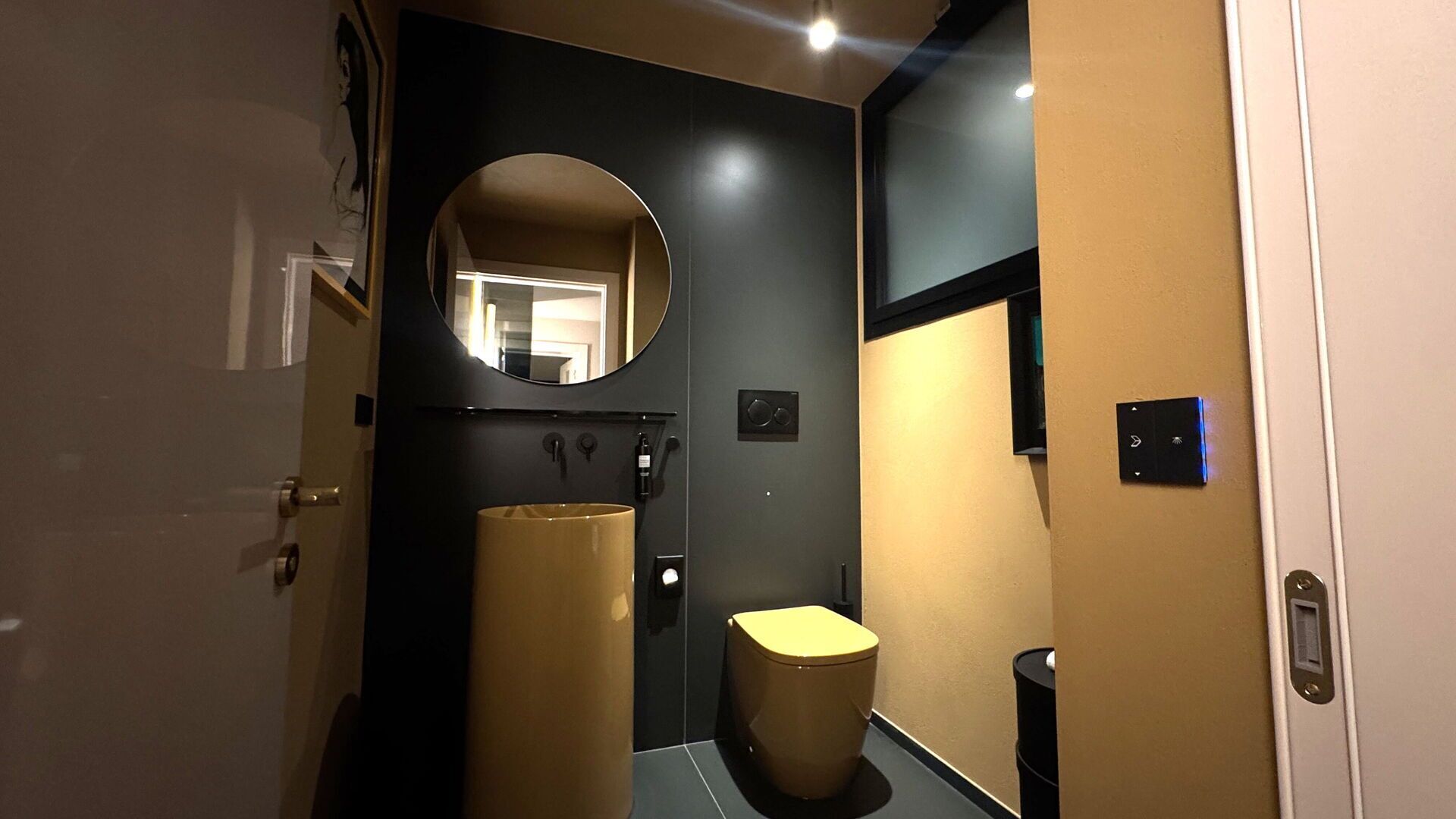 Ein schmales Entree mit Toilette, Waschbecken und Spiegel.