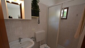 Ein Badezimmer mit Waschbecken, Toilette und Duschbereich.