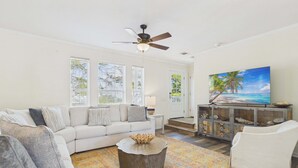 A living room with a sofa, coffee table, and TV. - Rolling Retreat 77–Gulfview Escape–Sleeps 16 (Santa Rosa Beach)