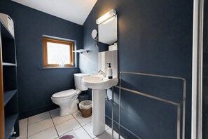 Ein Badezimmer mit Toilette, Waschbecken und einem Fenster.