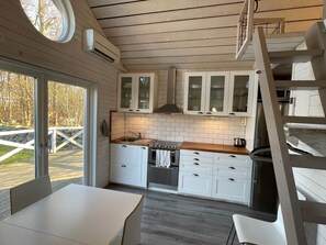 Eine moderne Küche mit weißen Schränken, einer Holzauskleidetheke und einem eingebauten Herd.