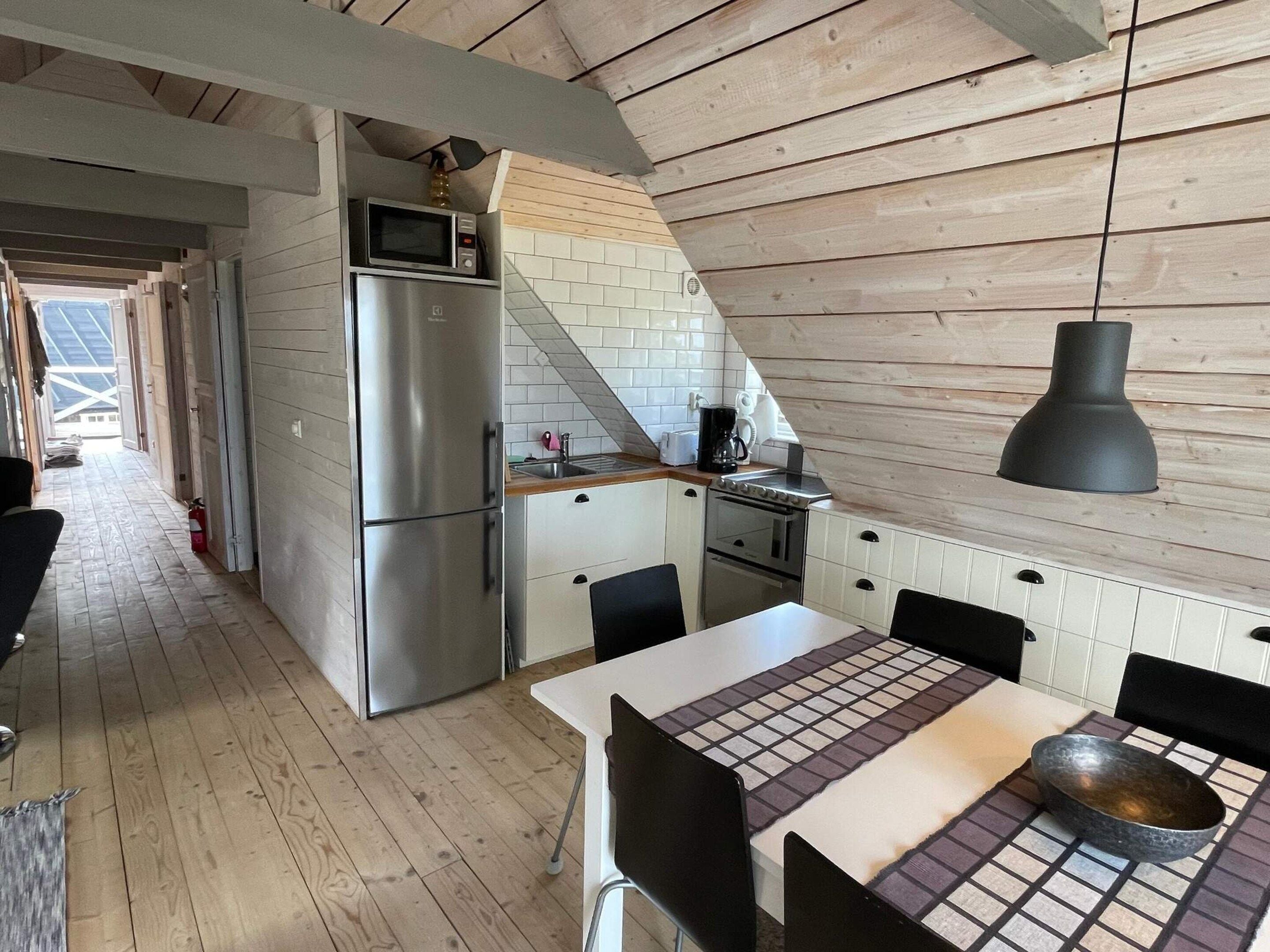 A compact kitchen with a refrigerator, microwave, and stove.
