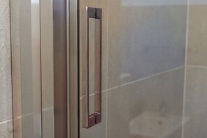 Un pomo metálico en una puerta, probablemente para un baño u otra habitación similar.