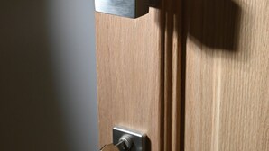Eine Holztür mit Schlüsselloch und Metallbeschlag.