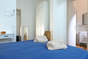 Ein Hotelzimmer mit Bett, Stuhl, Schreibtisch, Kleiderschrank und Bad.