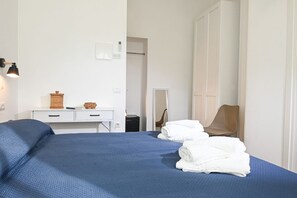 Ein Hotelzimmer mit Bett, Schreibtisch, Stuhl und Kleiderschrank.