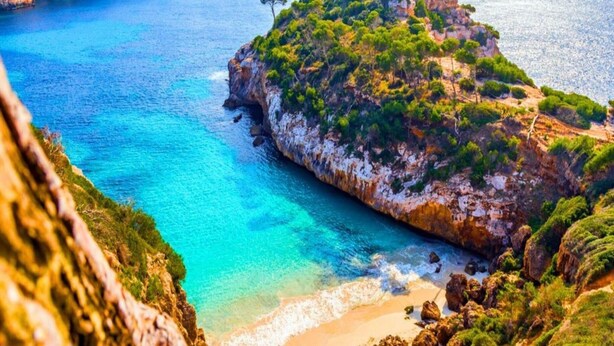 A coastal landscape with a rocky cliff, clear turquoise waters, and a sandy beach. - Cosy Apartment in Central Location (Conil de la Frontera)