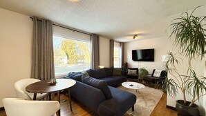 Una sala de estar moderna con un sofá, una mesa de comedor y un televisor.