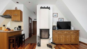 Een moderne keuken met houten kastjes, een inbouwfornuis en een eethoek met een bank.