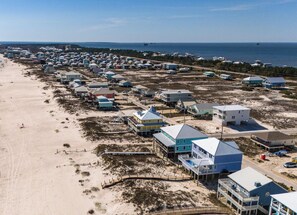 An aerial view of a coastal residential area with houses, a beach, and a pier. - Gorgeous 6 Br 7 Ba Beach Front Property W/ Private Pool (Gulf Shores)