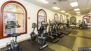 A gym with treadmills, ellipticals, and stationary bikes arranged in rows. - Regal Palms 4bd Resort Tiki Bar (Davenport)