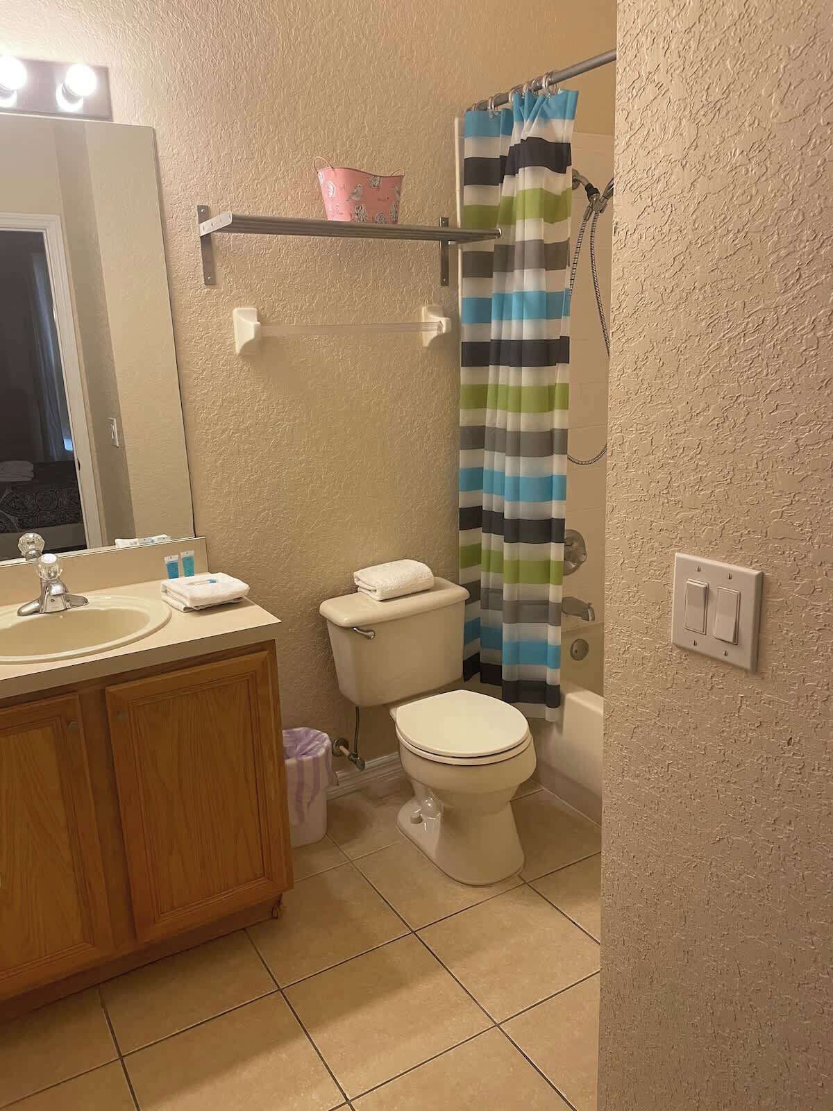 Een badkamer met een wastafel, toilet en douchegordijn.