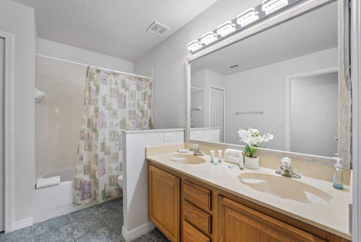 Une salle de bain avec une douche, un meuble-lavabo et un grand miroir.