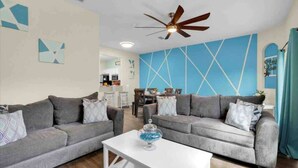 A living room with two grey sofas, a white coffee table, and a ceiling fan. - Cute 3bd 2 5bth Amazing Resort (Davenport)