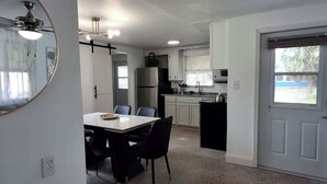 A compact kitchen with white cabinets, a refrigerator, and a sink. - The Sandcastle-walk to the Beach and John s Pass (Madeira Beach)