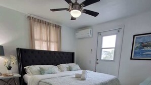 A neatly arranged bedroom with a bed, bedside table, and a ceiling fan. - The Sandcastle-walk to the Beach and John s Pass (Madeira Beach)