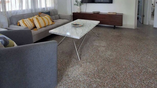 A living room with a sofa, a coffee table, a TV, and a ceiling fan. - The Sandcastle-walk to the Beach and John s Pass (Madeira Beach)